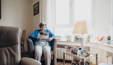 personne sur un fauteil en train de lire une brochure